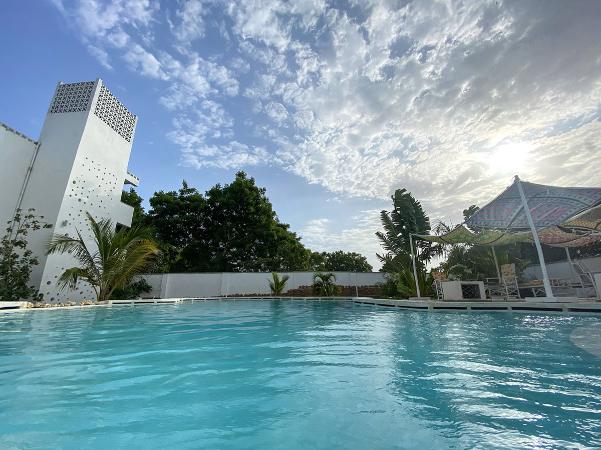 Swimming pool with modern white tower building and cabana at Aqua Resort